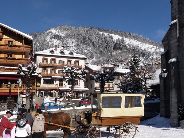 Hotel la Pointe Percee outside front Snowy mountain village resort with horse-drawn carriage